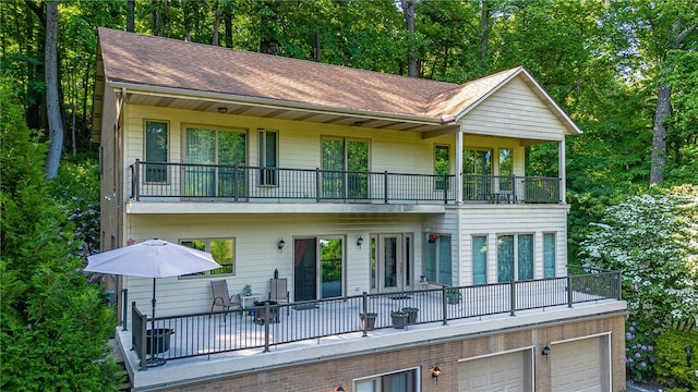 rear view of property with a balcony and a garage