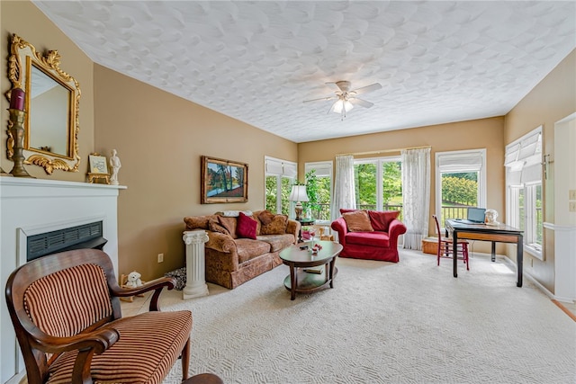 carpeted living room with a textured ceiling and ceiling fan