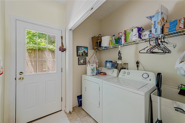 laundry room featuring washer and clothes dryer and light tile patterned floors