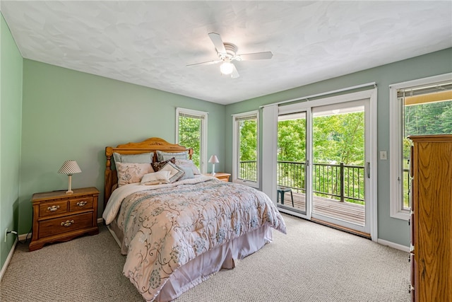 bedroom featuring light colored carpet, multiple windows, access to outside, and ceiling fan