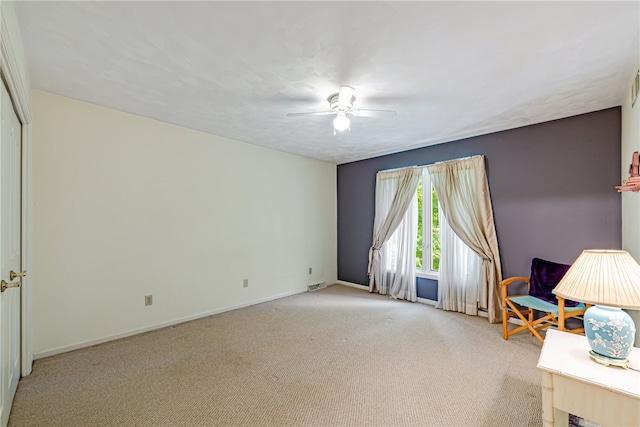 living area featuring light carpet and ceiling fan