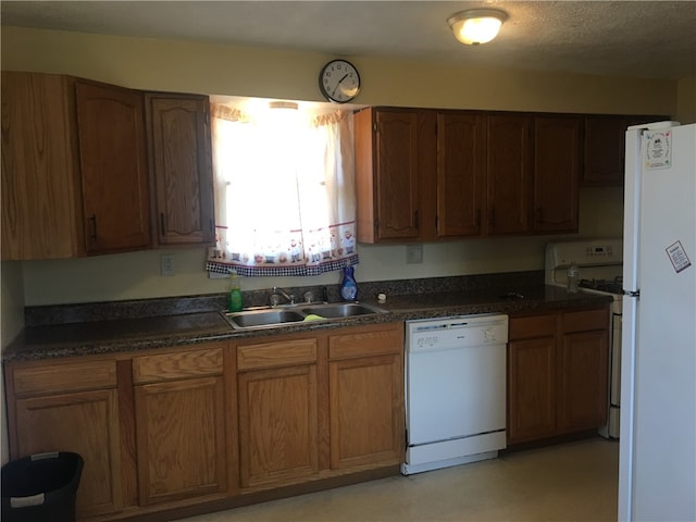 kitchen with a textured ceiling, sink, and white appliances