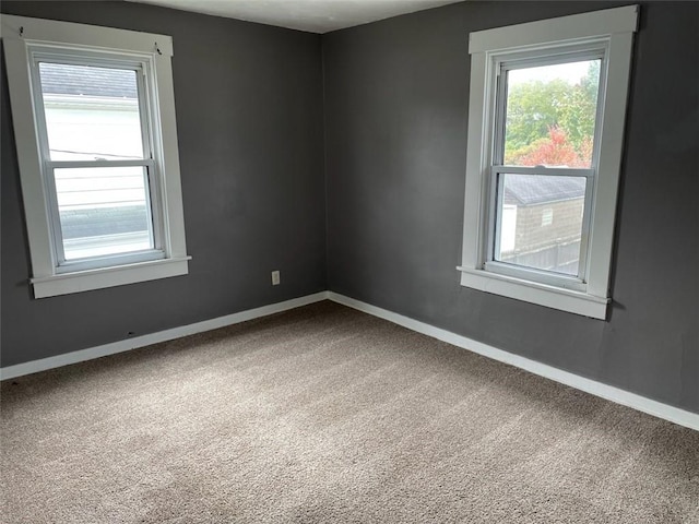 unfurnished room with baseboards, carpet flooring, and a healthy amount of sunlight