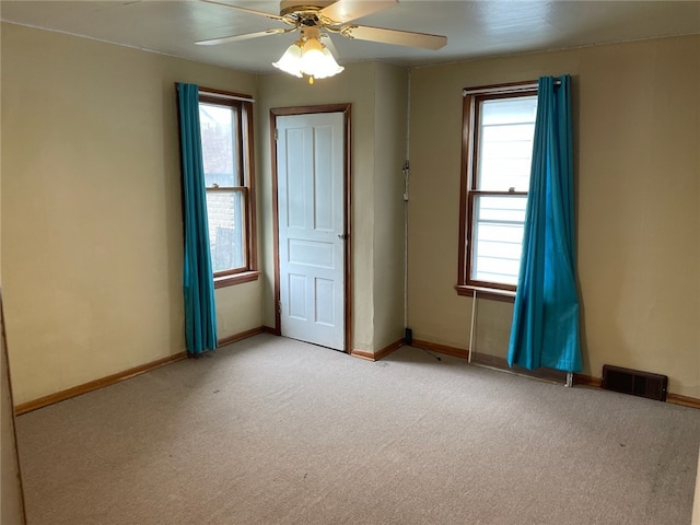 carpeted spare room featuring ceiling fan