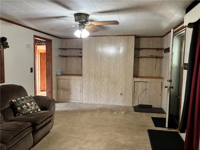 living room featuring crown molding, wooden walls, light carpet, and ceiling fan