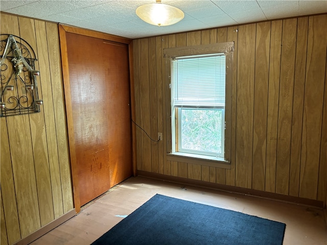 unfurnished room featuring wooden walls and light wood-type flooring