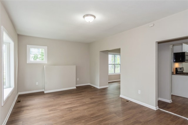 unfurnished room featuring wood-type flooring and a wealth of natural light