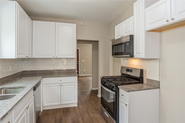 kitchen with appliances with stainless steel finishes, tasteful backsplash, dark hardwood / wood-style floors, and white cabinets