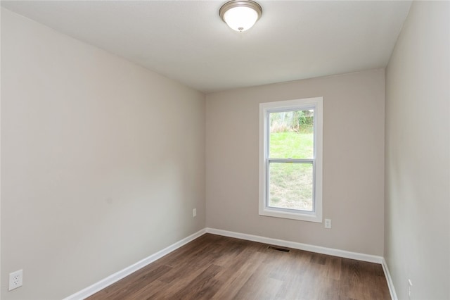 unfurnished room with dark hardwood / wood-style flooring