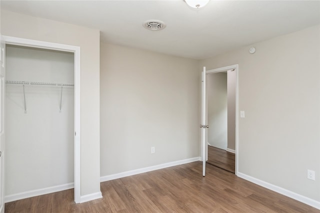 unfurnished bedroom featuring wood-type flooring and a closet