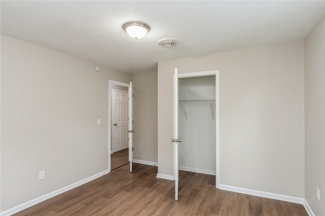 unfurnished bedroom with wood-type flooring and a closet