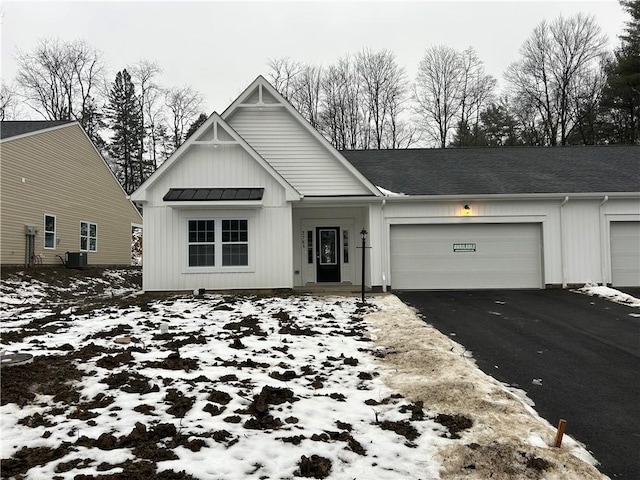 view of front of home featuring a garage and central AC