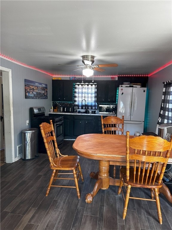 dining area featuring ceiling fan, dark hardwood / wood-style floors, and sink