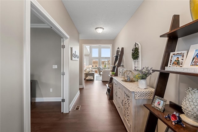 corridor with dark hardwood / wood-style floors and a textured ceiling