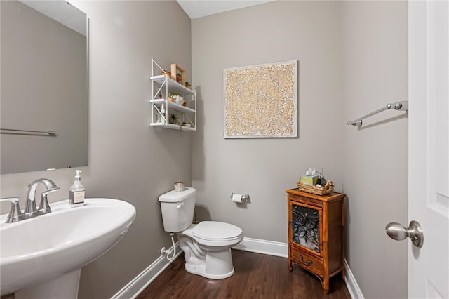 bathroom featuring wood-type flooring, sink, and toilet