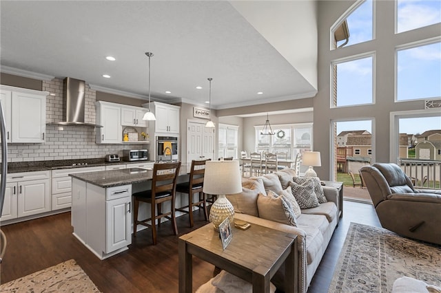 living room featuring dark hardwood / wood-style floors, ornamental molding, and a wealth of natural light