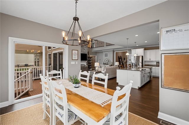 dining room with a notable chandelier and dark hardwood / wood-style flooring