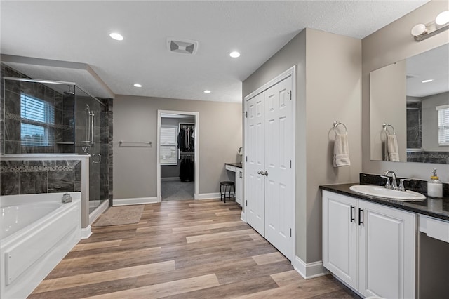 bathroom featuring wood-type flooring, vanity, and shower with separate bathtub