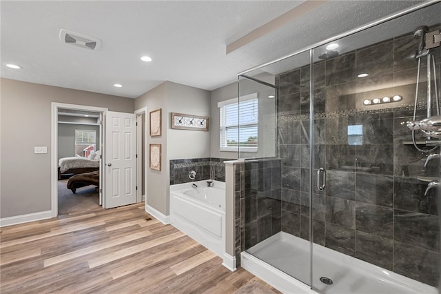 bathroom with hardwood / wood-style flooring and separate shower and tub