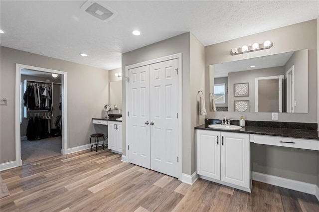 bathroom featuring vanity, hardwood / wood-style floors, and a textured ceiling