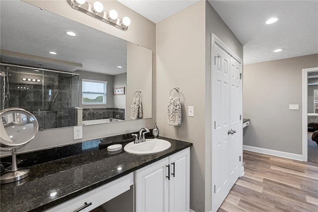 bathroom featuring vanity, a shower with door, and hardwood / wood-style flooring