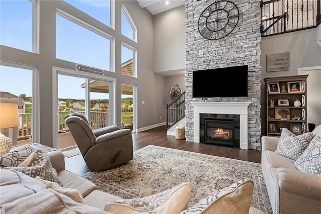 living room featuring a fireplace, dark hardwood / wood-style floors, and a high ceiling