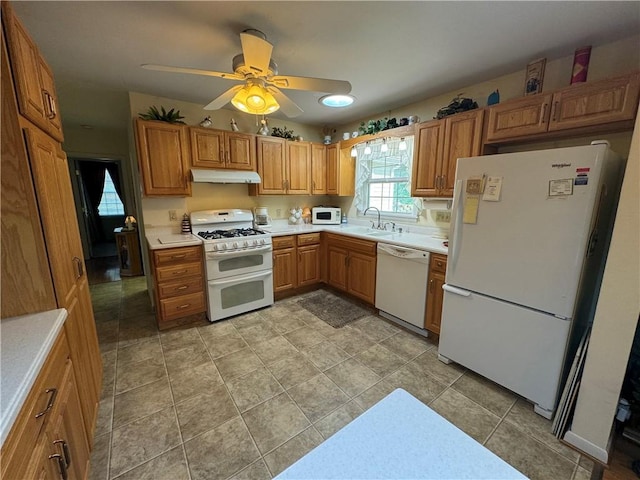 kitchen with white appliances, light countertops, a ceiling fan, under cabinet range hood, and a sink