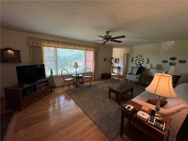 living room with light wood-type flooring and a ceiling fan