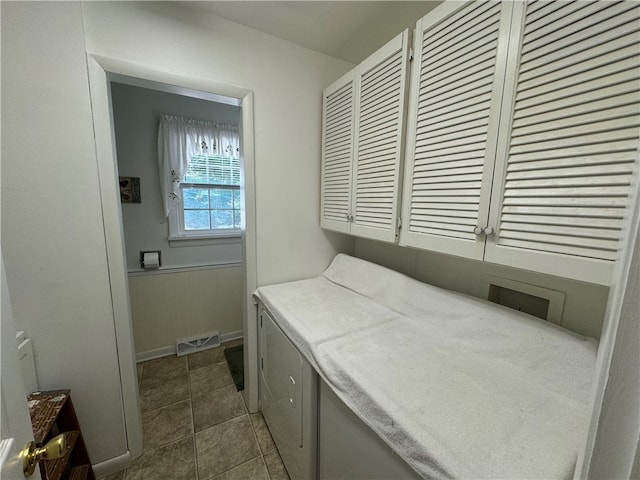 laundry room featuring cabinets, washing machine and clothes dryer, and dark tile patterned floors