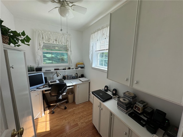 office space featuring light hardwood / wood-style flooring, built in desk, and ceiling fan