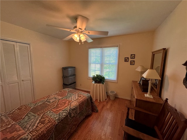 bedroom with ceiling fan, a closet, and wood-type flooring