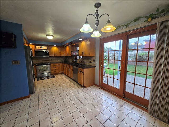 kitchen with a notable chandelier, appliances with stainless steel finishes, hanging light fixtures, and light tile patterned floors