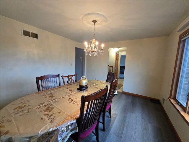 dining space featuring a notable chandelier and dark hardwood / wood-style floors