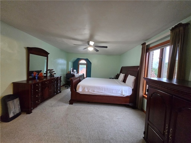 bedroom with a textured ceiling, light carpet, and ceiling fan