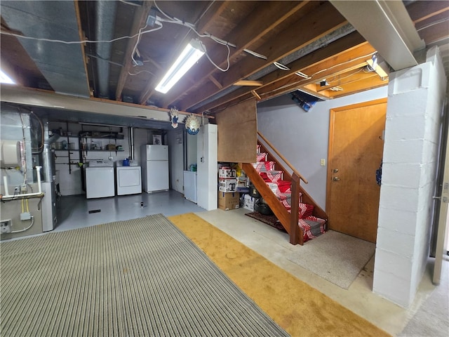 basement with washing machine and dryer and white fridge