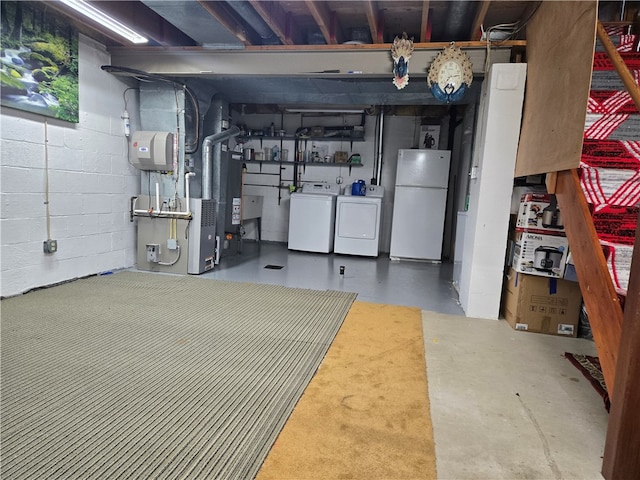 basement featuring white fridge and washing machine and clothes dryer