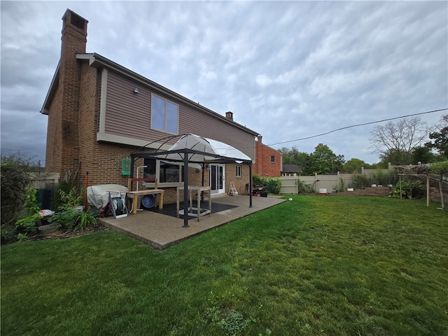 back of property with a yard and a patio area