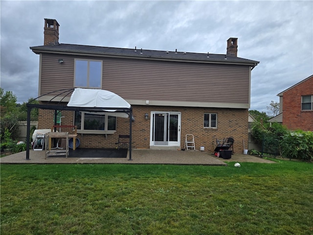 back of property featuring a lawn and a patio area