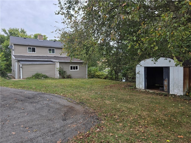 view of yard featuring a garage and a storage shed