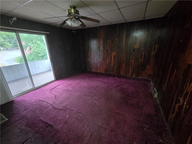 unfurnished room with carpet floors, a drop ceiling, and ceiling fan