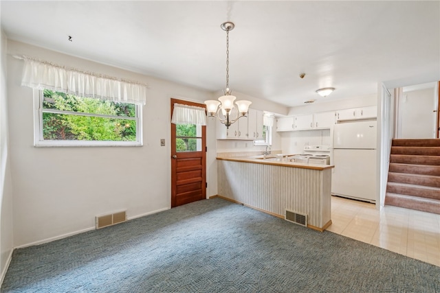 kitchen featuring a chandelier, white cabinetry, kitchen peninsula, hanging light fixtures, and white fridge