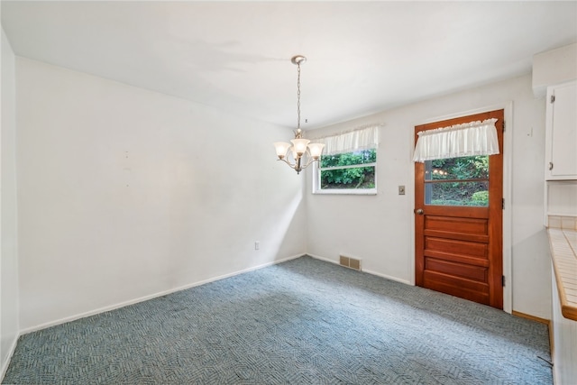 unfurnished dining area featuring carpet floors and a notable chandelier