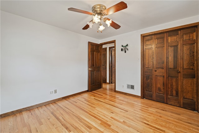 unfurnished bedroom featuring light hardwood / wood-style flooring, a closet, and ceiling fan