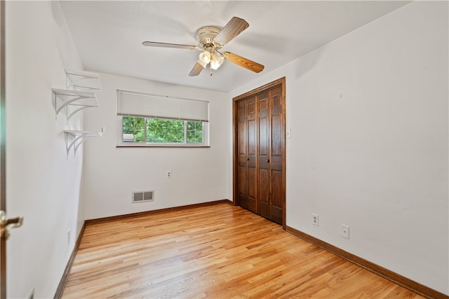 unfurnished bedroom featuring light hardwood / wood-style flooring, a closet, and ceiling fan