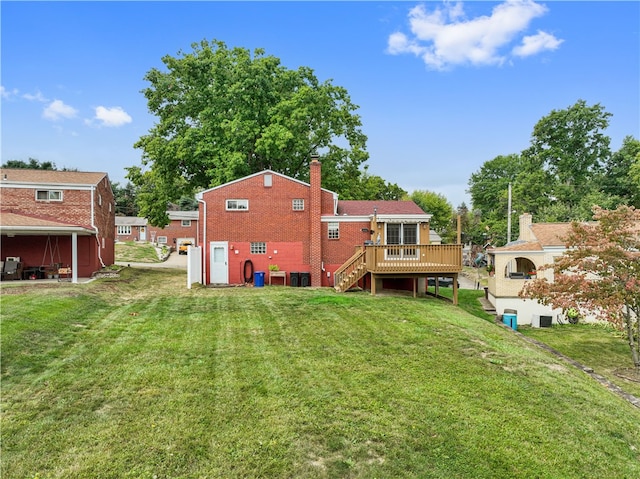 back of property featuring a wooden deck and a lawn