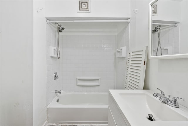 bathroom with radiator heating unit, tiled shower / bath combo, and vanity