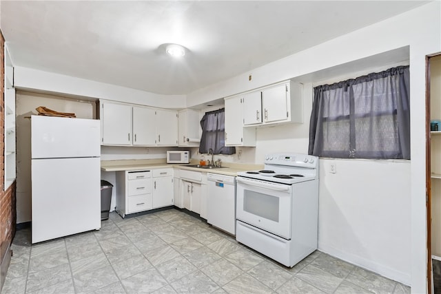 kitchen featuring sink, white appliances, and white cabinetry