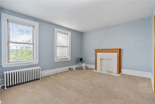 interior space featuring radiator heating unit, light carpet, and a healthy amount of sunlight