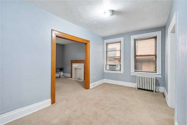 carpeted empty room featuring radiator