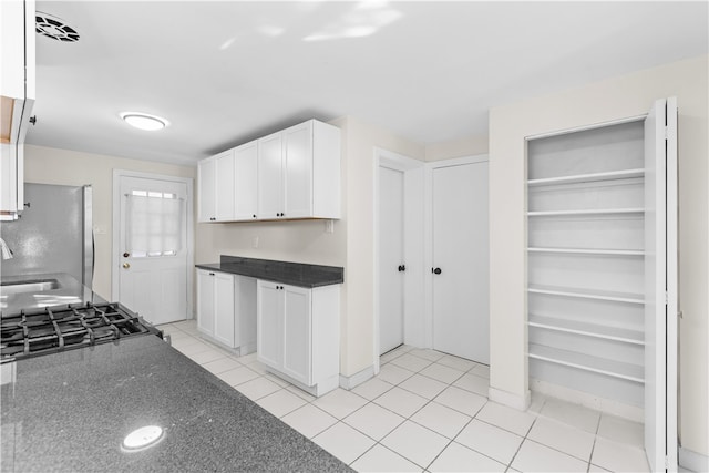 kitchen featuring white cabinets, light tile patterned flooring, and stainless steel appliances